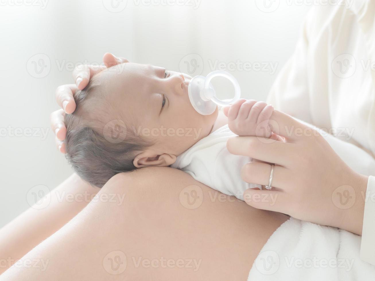 A beautiful Asian woman puts her newborn baby on her body photo