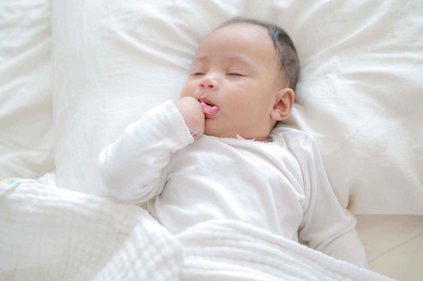 un bastardo recién nacido está envuelto en un paño blanco y duerme en una cama foto