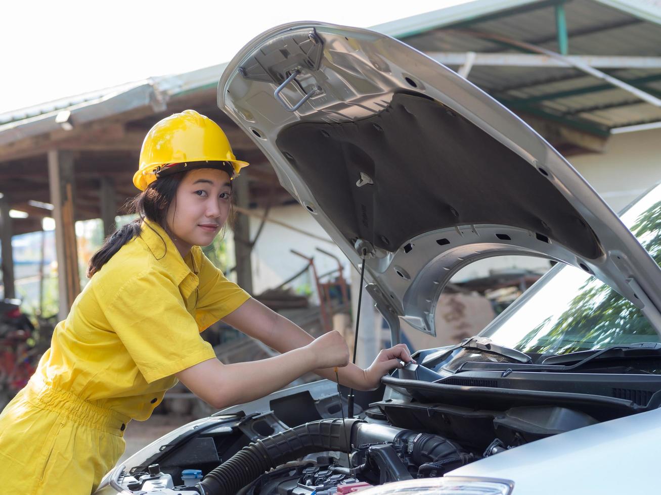 Women in work uniforms are measuring car engine oil levels photo