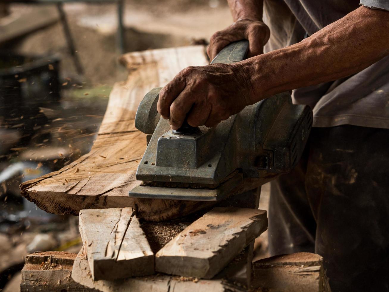 Professional technicians in the factory are using power tools to polish the wooden photo