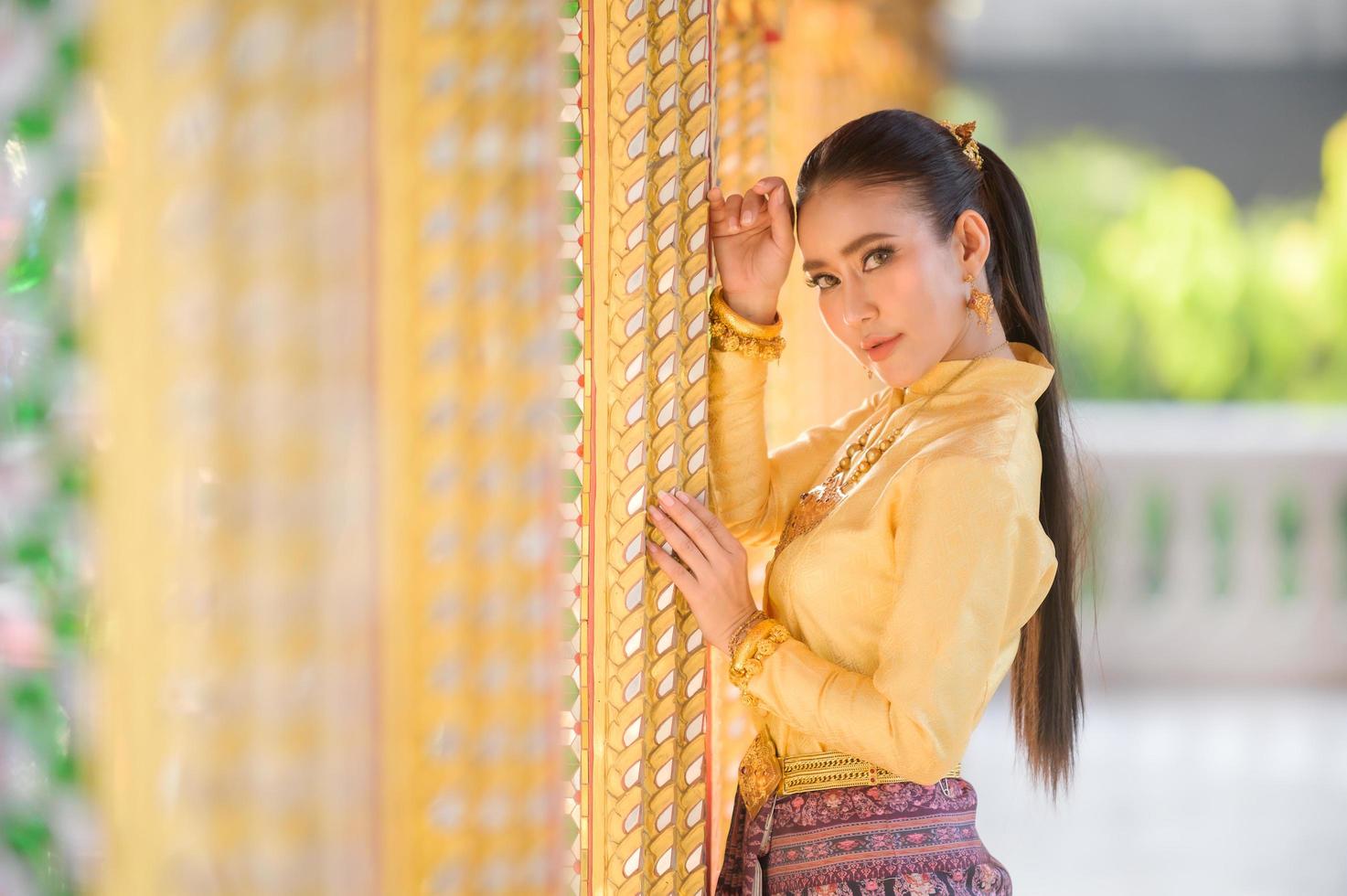 Charming Thai women in traditional Thai costumes prepare to pay homage to the Buddha in a Thai temple to pray for the Songkran tradition in Thailand photo