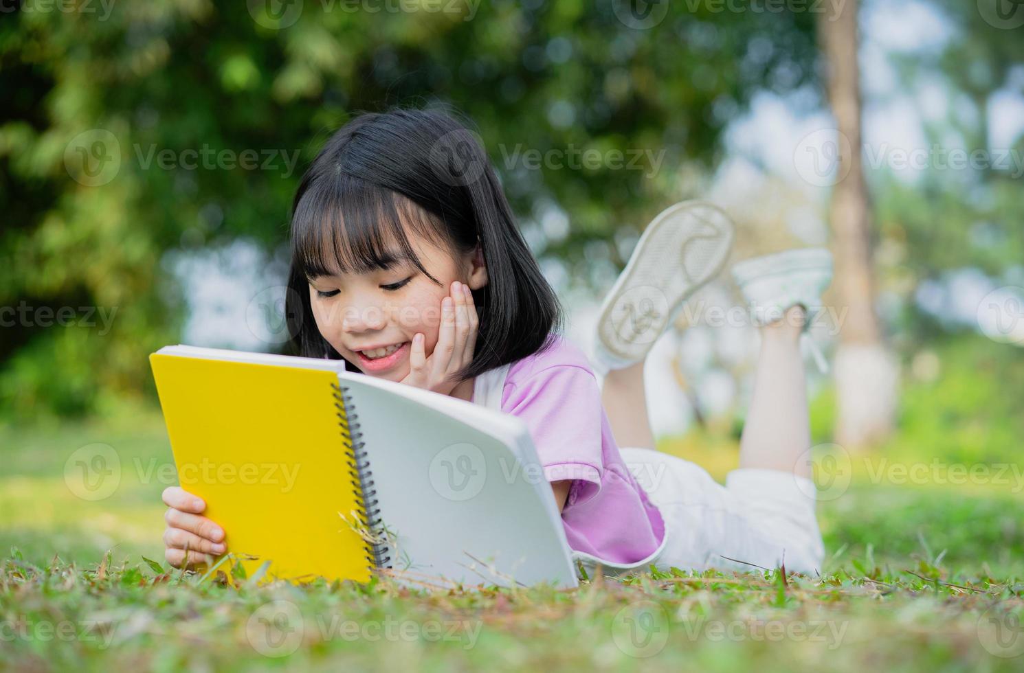 Image of Asian little girl studying at park photo