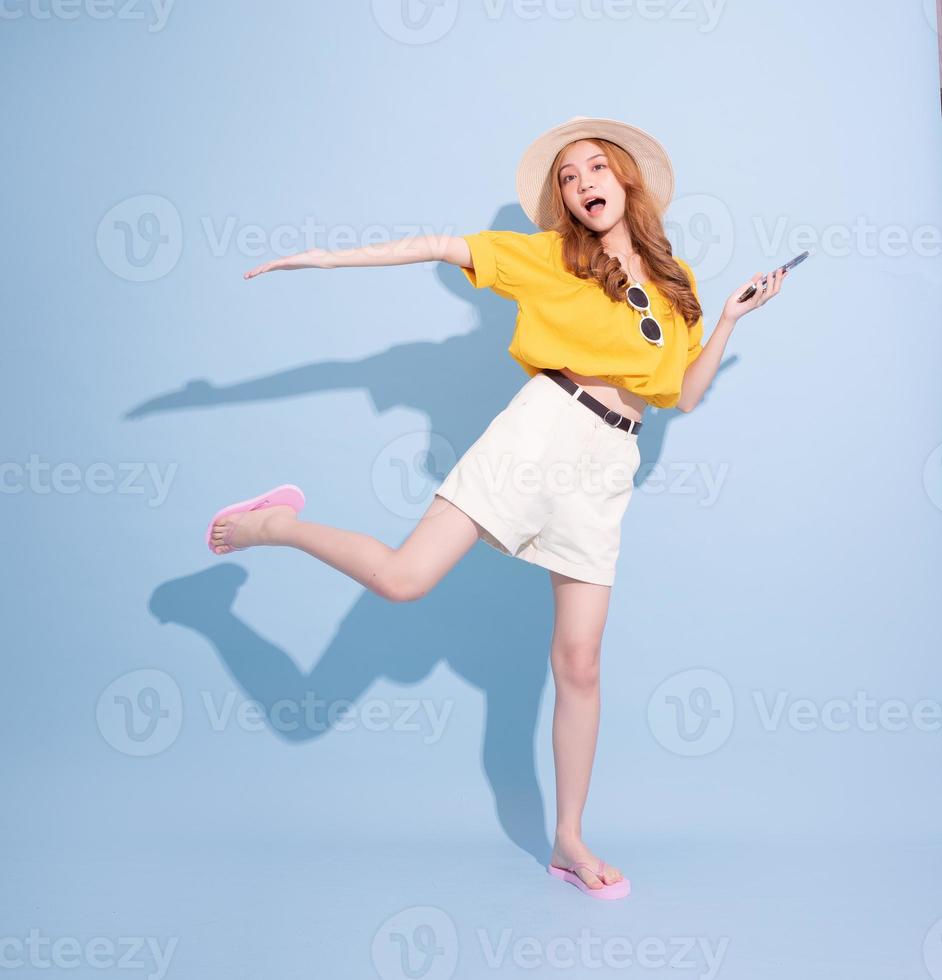Portrait of young Asian girl on blue background, summer vacation concept photo