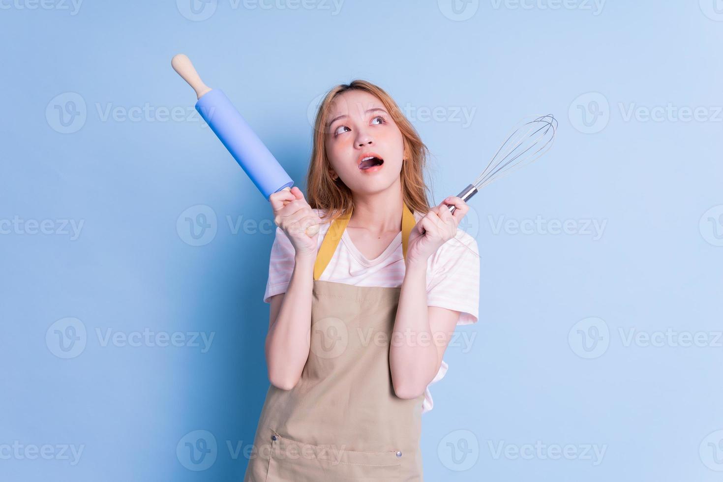 retrato de ama de casa posando sobre fondo azul foto