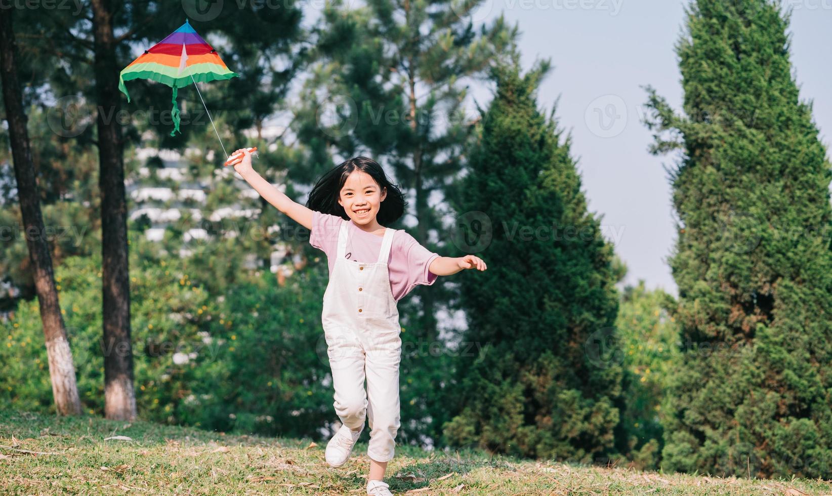 Image Asian little girl playing kite in the park photo