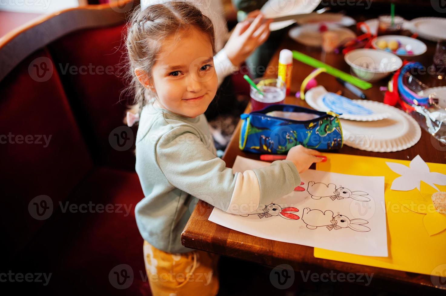 Preparing to Easter concept. Little girl drawing bunny. photo