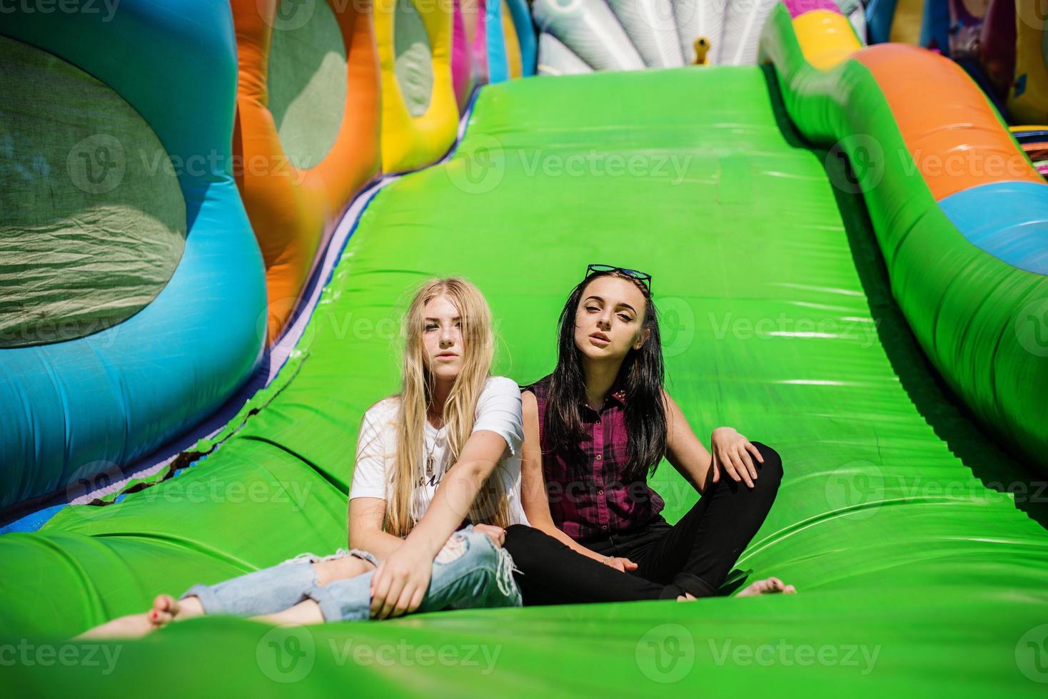 Gorgeous girls having fun on a slide on a sunny day. photo