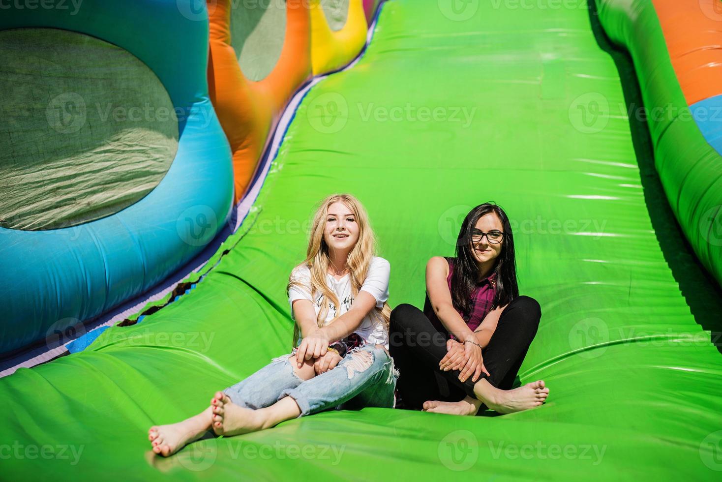 Gorgeous girls having fun on a slide on a sunny day. photo