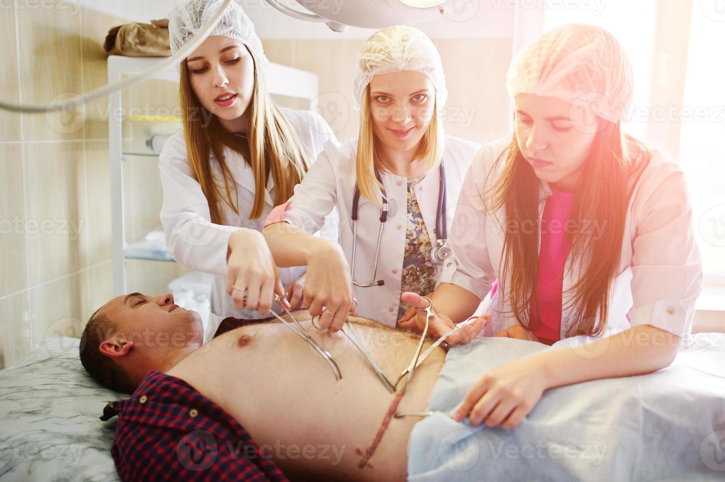 Young talented surgeons performing operation on their patient. photo