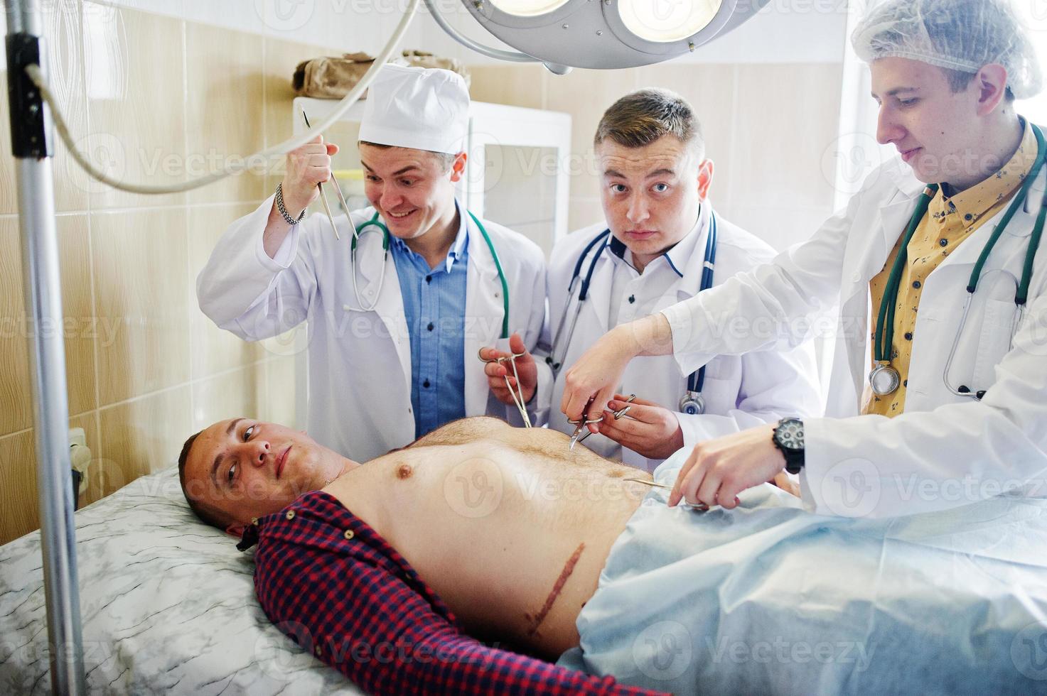 Young talented surgeons performing operation on their patient. photo