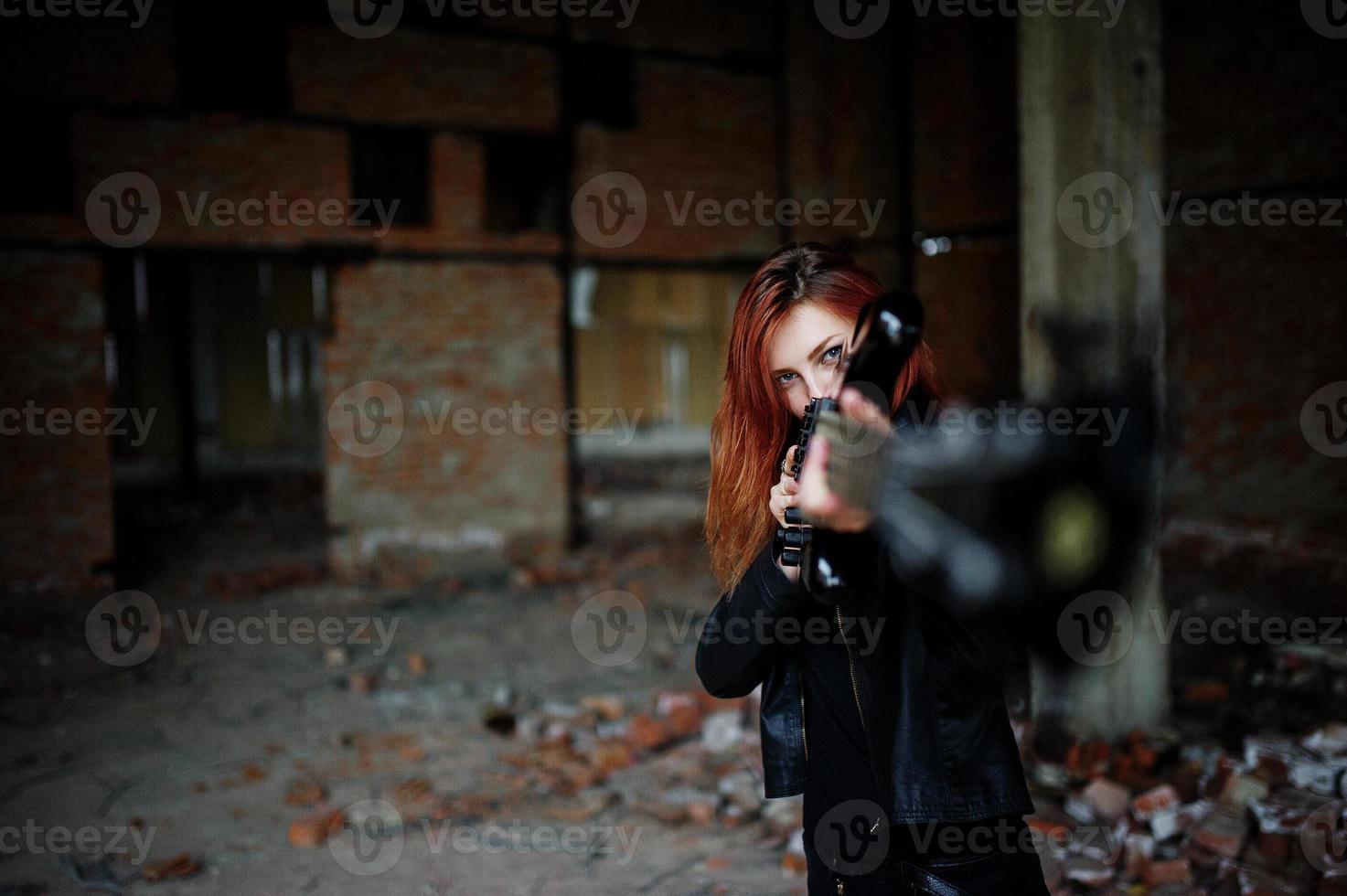 Chica punk pelirroja vestida de negro con bajo en un lugar abandonado. retrato de mujer gótica músico. foto