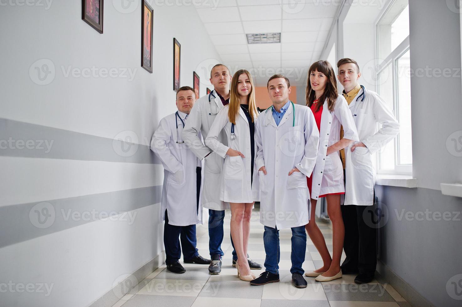 grupo de médicos jóvenes con batas blancas posando en el hospital. foto