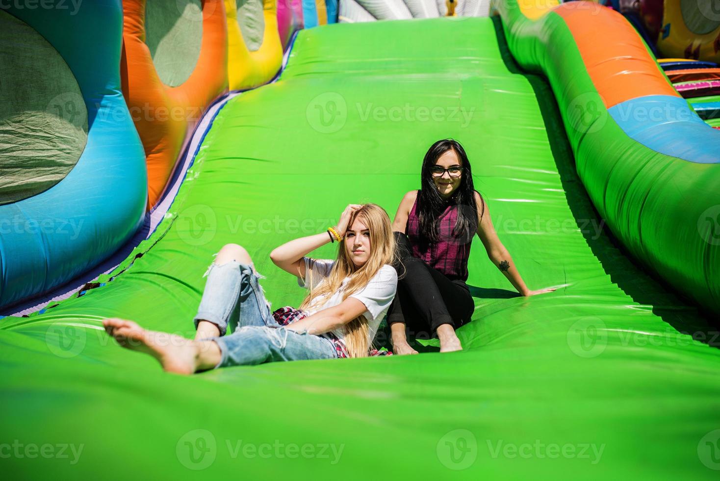 Gorgeous girls having fun on a slide on a sunny day. photo
