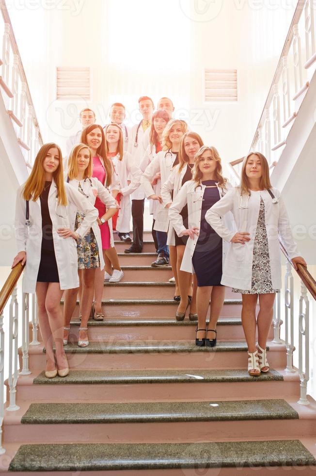 Group of young doctors in white coats posing in the hospital. photo