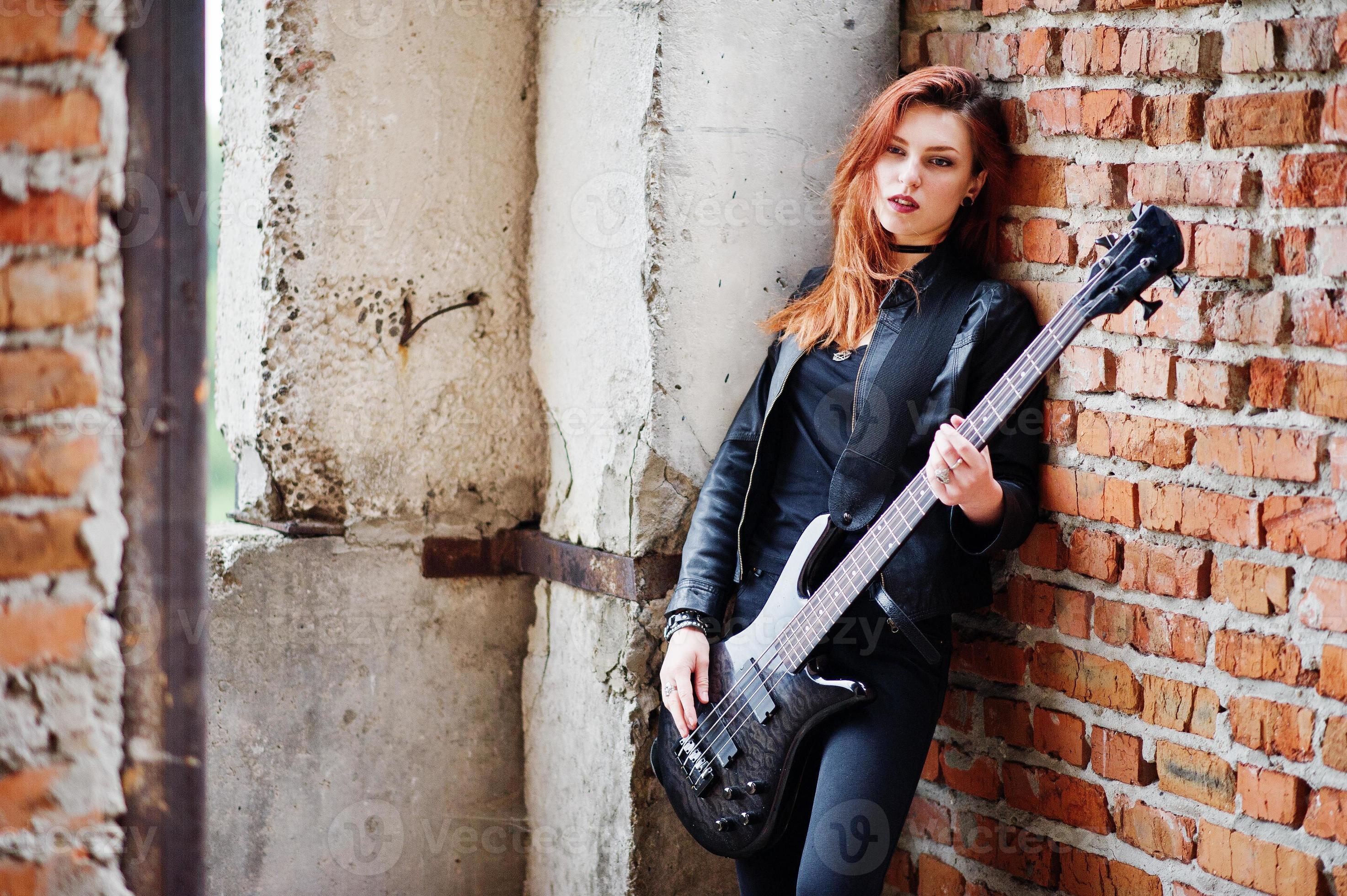 https://static.vecteezy.com/system/resources/previews/007/219/649/large_2x/red-haired-punk-girl-wear-on-black-with-bass-guitar-at-abadoned-place-portrait-of-gothic-woman-musician-photo.jpg