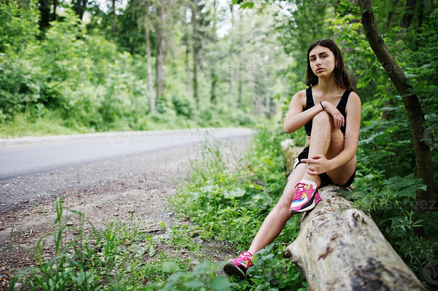 chica deportiva en ropa deportiva descansando en un parque verde después de entrenar en la naturaleza. un estilo de vida saludable. foto