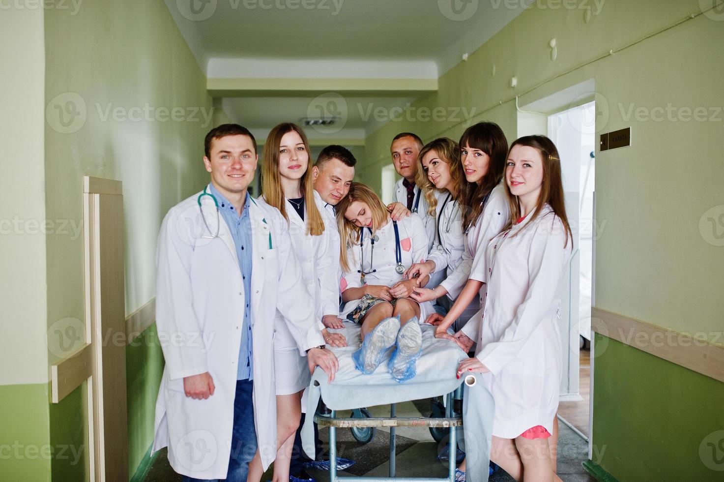 médicos divertidos posando en la cama para pacientes enfermos en el hospital. foto