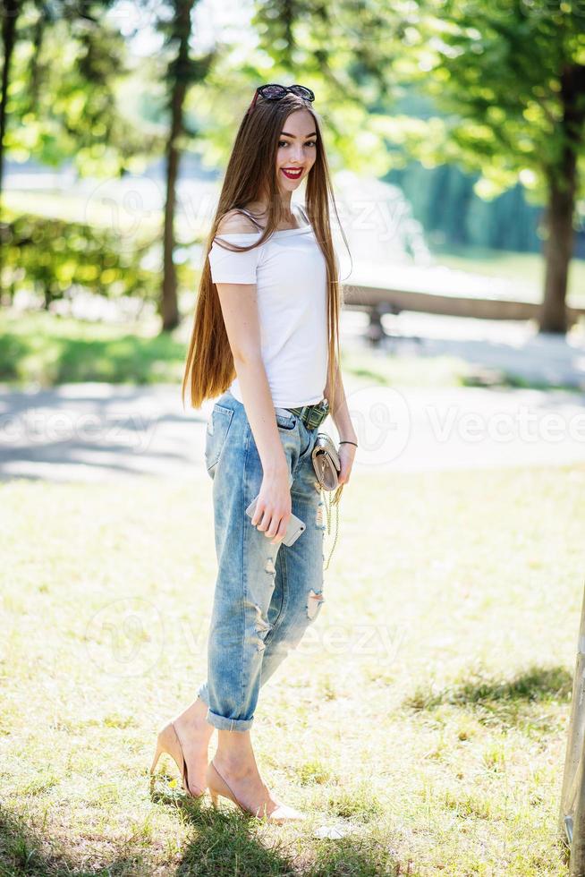 primer plano retrato de una fantástica joven modelo posando en el parque en un día soleado. foto