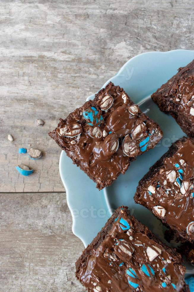 cuadrados de brownie con trozos de caramelo azul brillante y chocolate rociado en la parte superior plana foto
