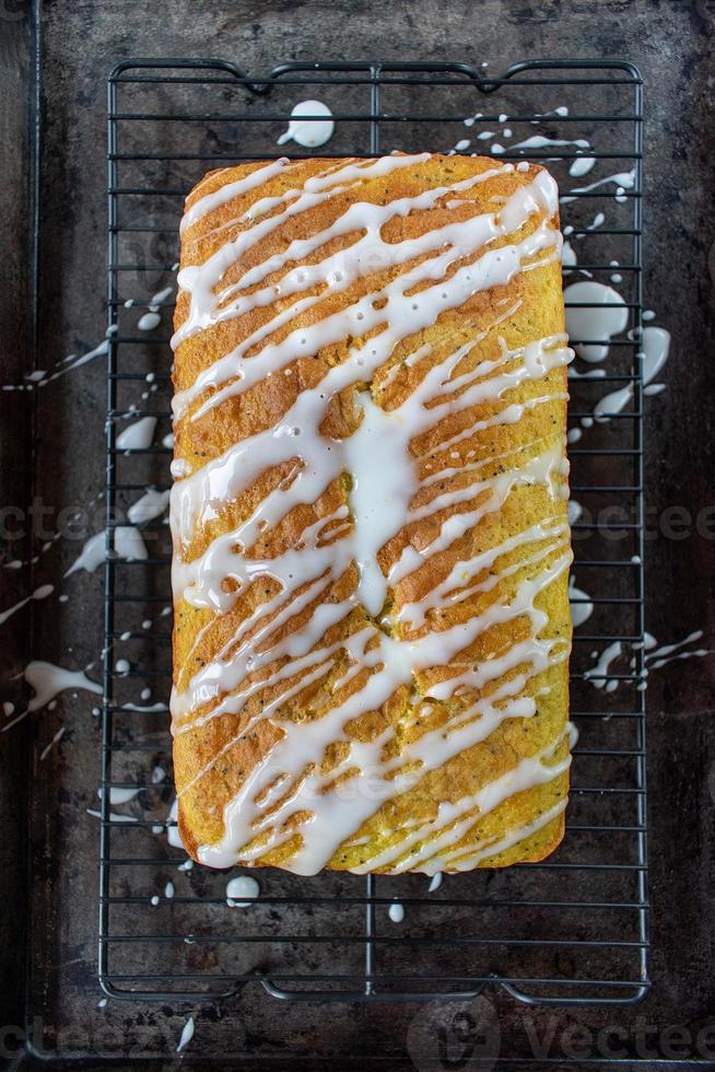 baked lemon poppy seed cake loaf with white icing drizzle flat lay