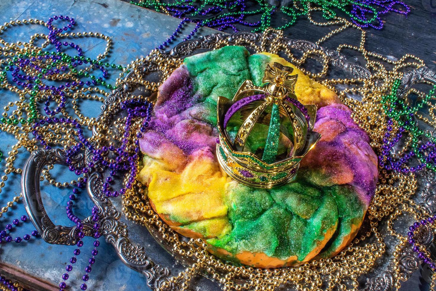 pastel de rey con corona rodeado de cuentas de mardi gras foto