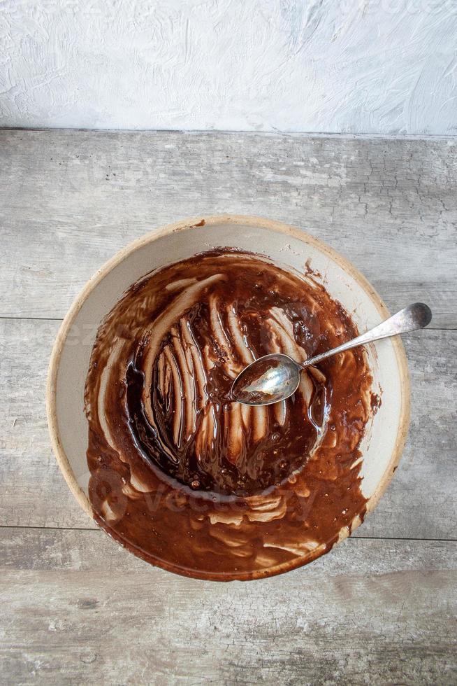 farmhouse bowl and spoon with remnants of brownie mixture flat lay photo