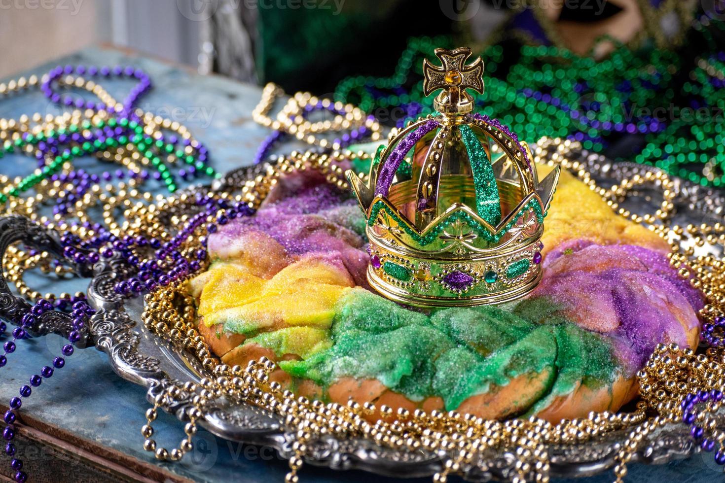 king cake with crown surrounded by mardi gras beads photo