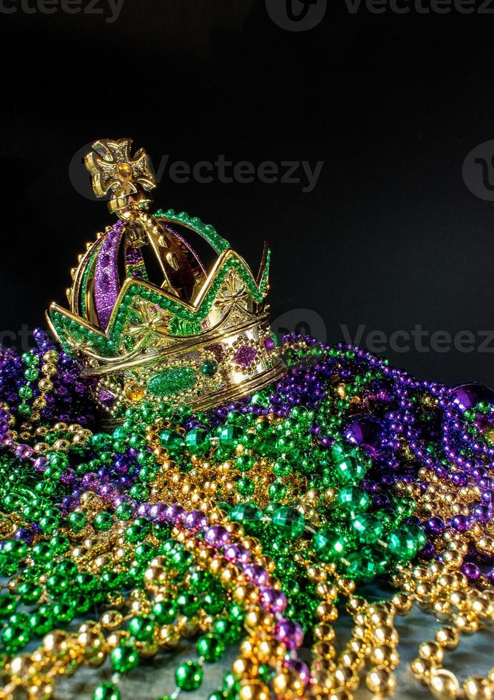 New Orleans mardi gras crown and beads in green, gold, and purple with copy space photo