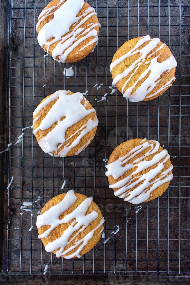 baked lemon poppy seed cupcakes with white icing drizzle flat lay
