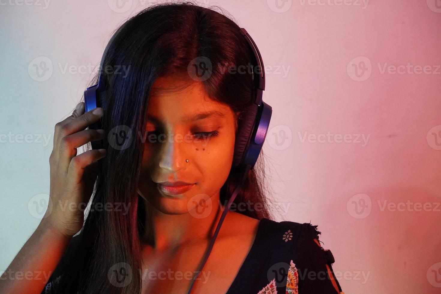 una chica asiática con auriculares y escuchando música foto
