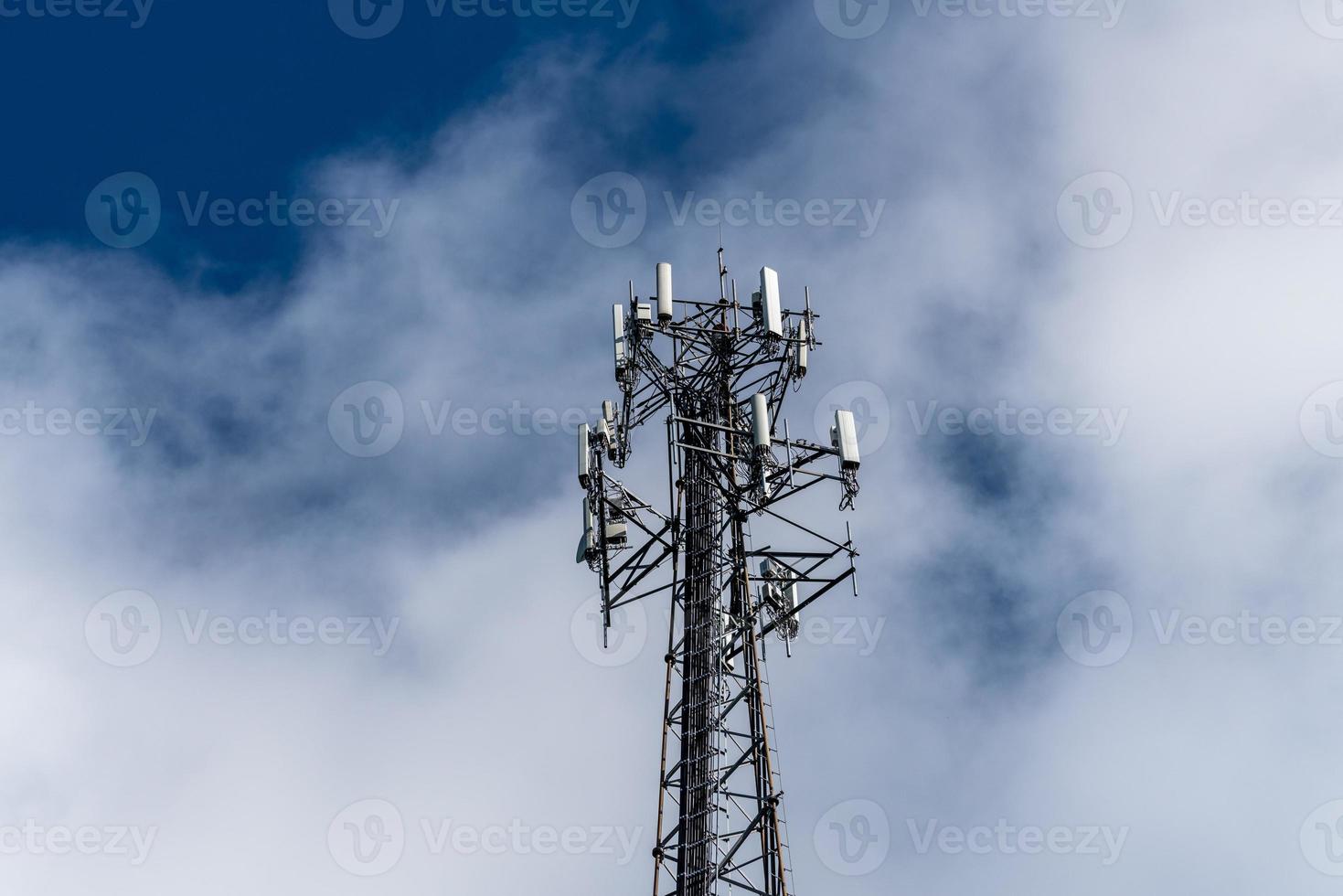 Cell phone or mobile service tower providing broadband internet service against blue sky photo