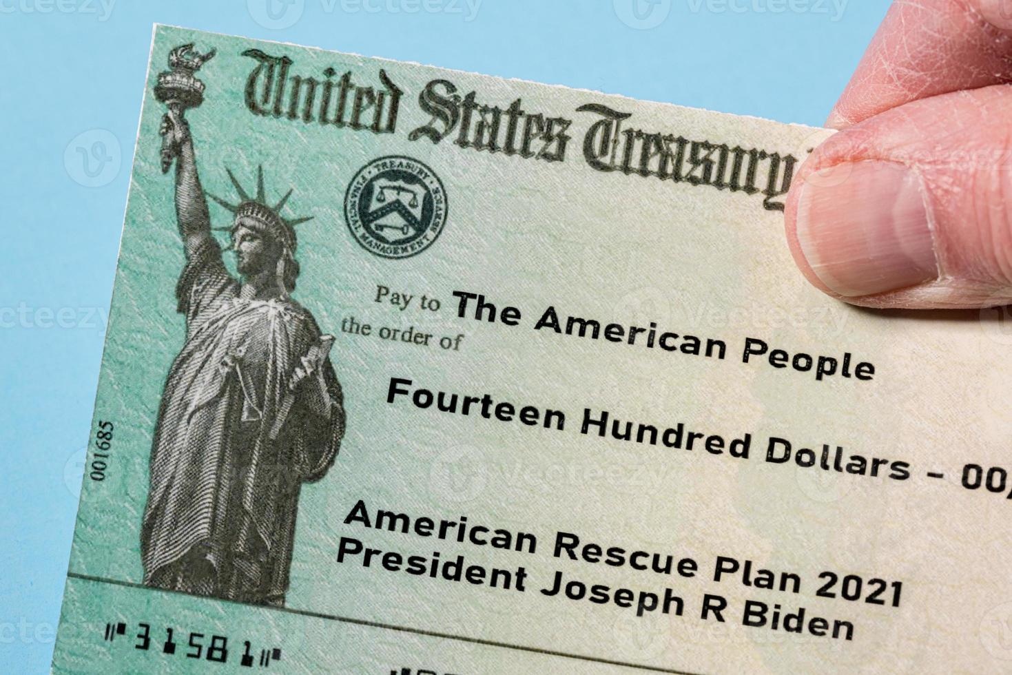 Illustration of the 2021 federal stimulus payment check from the IRS with hand photo