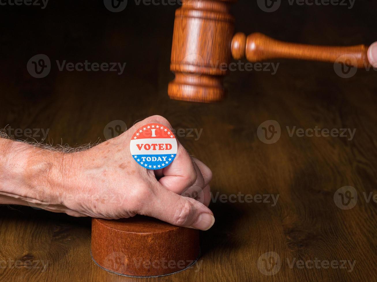 I voted campaign button or sticker on hand with a gavel and mallet to illustrate lawsuits about voting photo