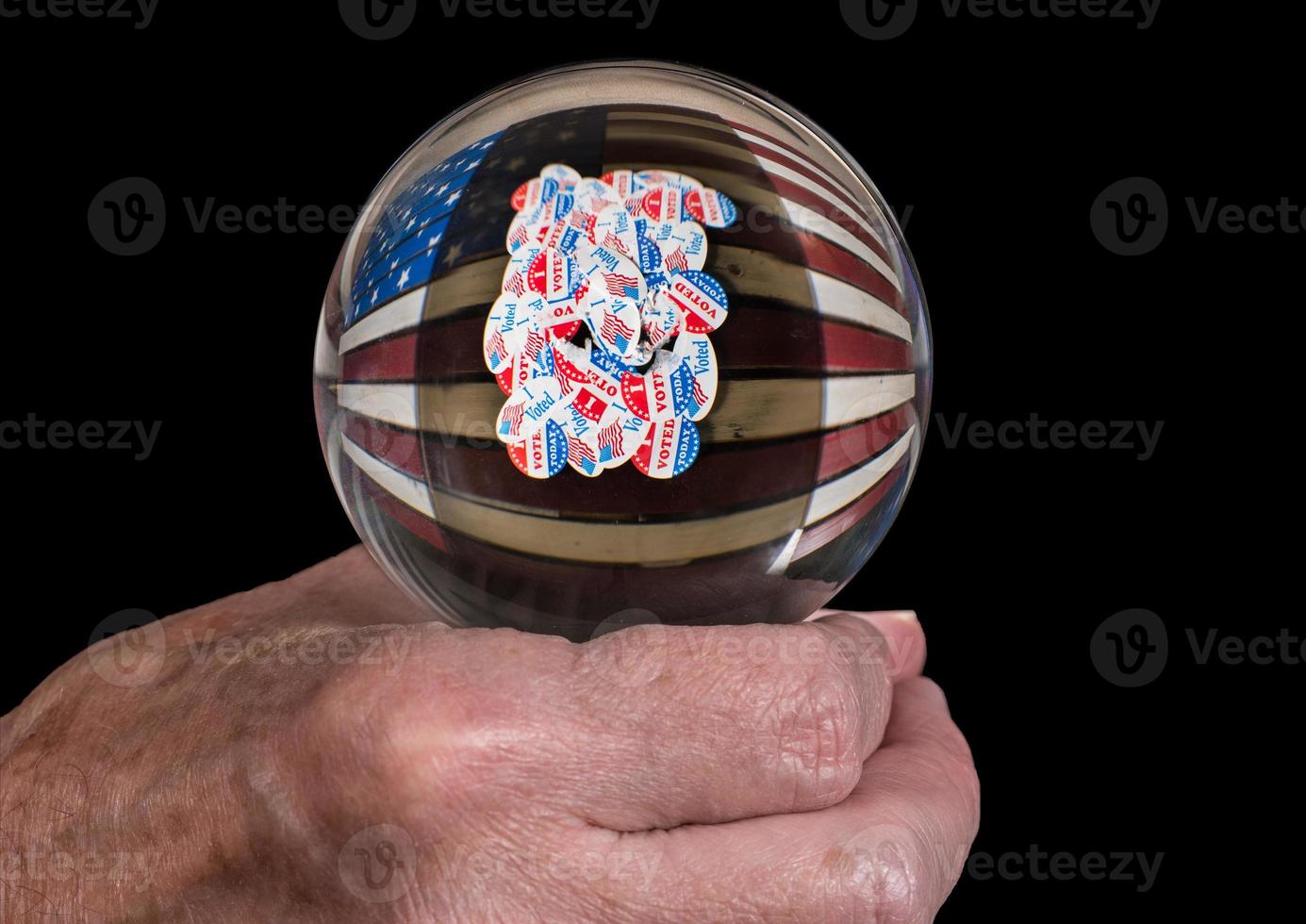 Senior mans hand holding a glass fortune telling ball to predict the results of the US election photo