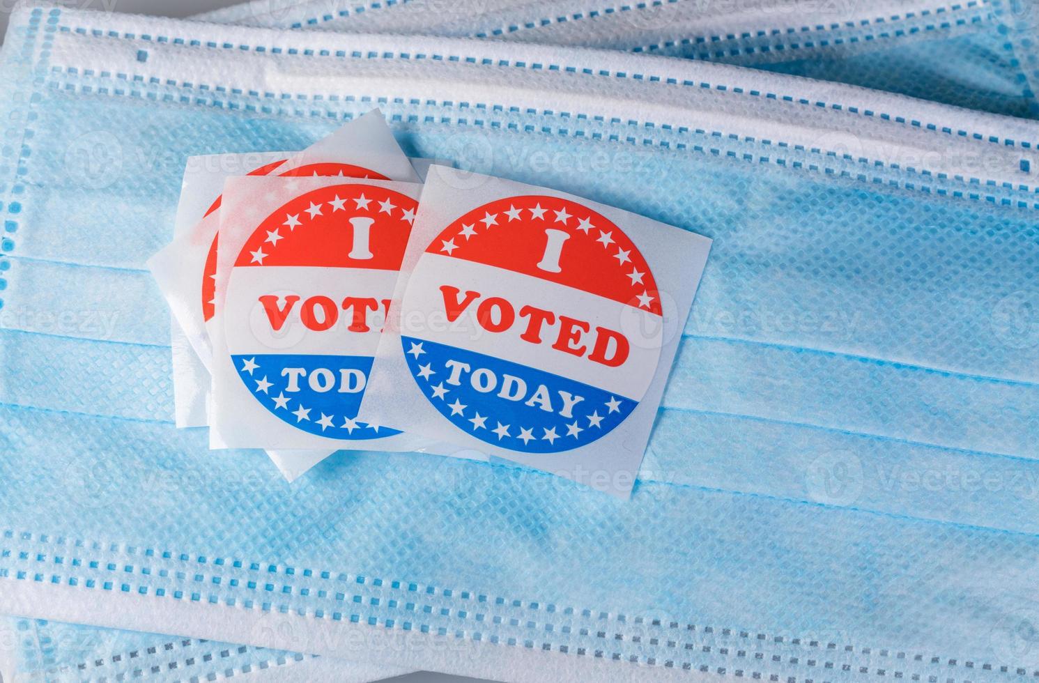 I Voted Today paper sticker on medical face mask to illustrate in person voting photo