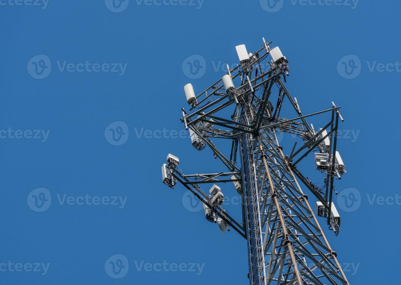 Cell phone or mobile service tower providing broadband internet service against blue sky photo