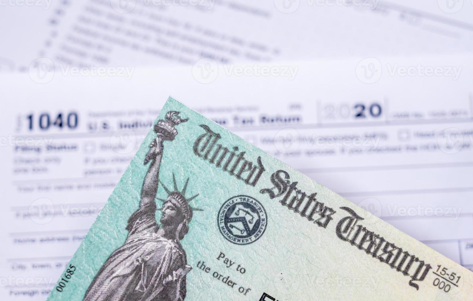 US Treasury check for stimulus in 2020 against a USA Form 1040 photo