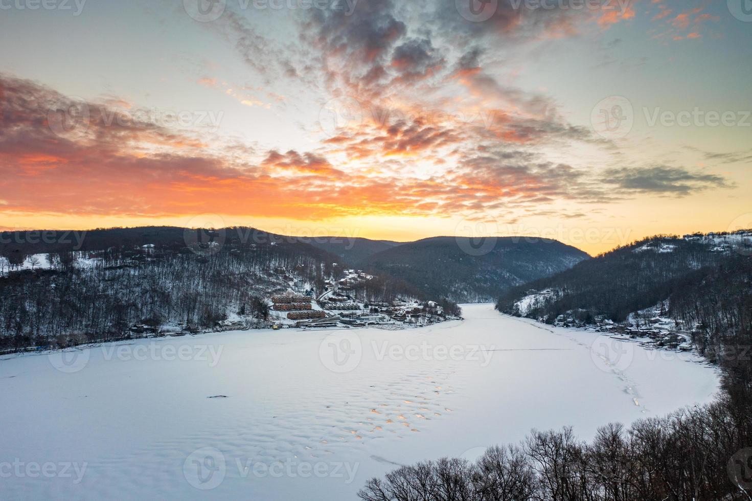 salida del sol aérea sobre el lago tramposo congelado morgantown, wv foto