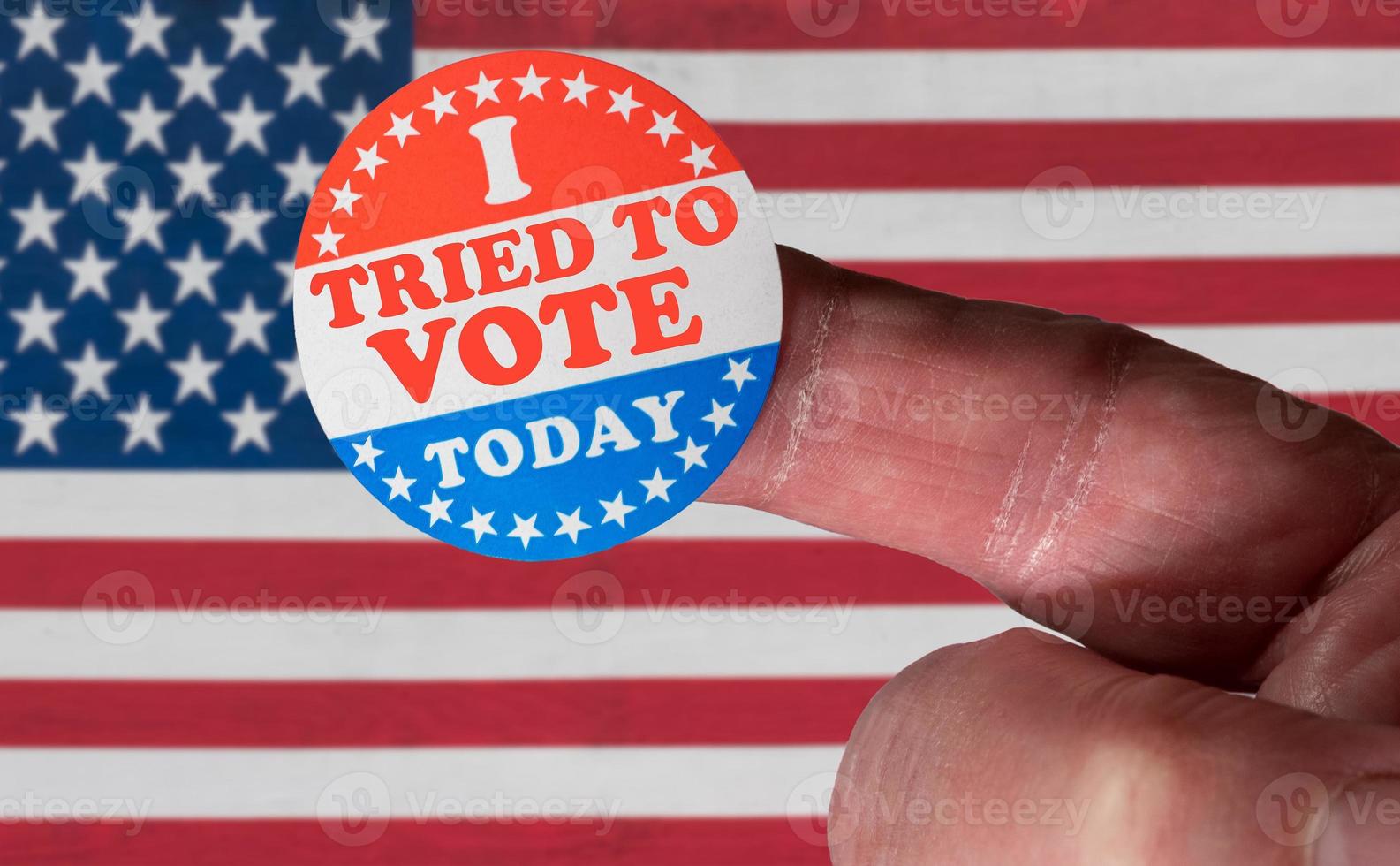 Finger with I Tried to Vote sticker in front of many election voting badges with problems getting a vote photo