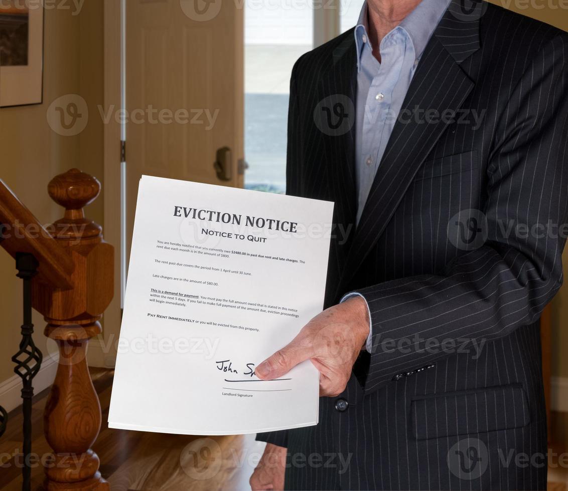 Man in suit giving eviction notice to renter or tenant of home photo