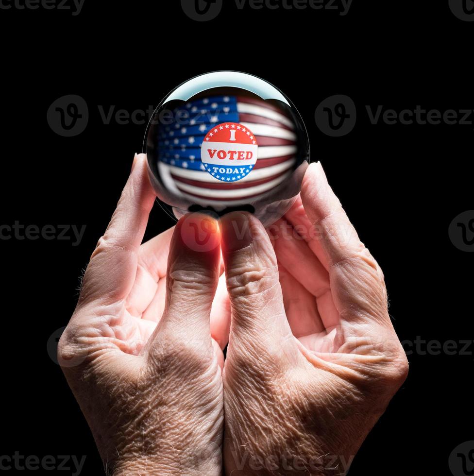 Hands holding a crystal glass forecasting ball to predict the result of the election photo