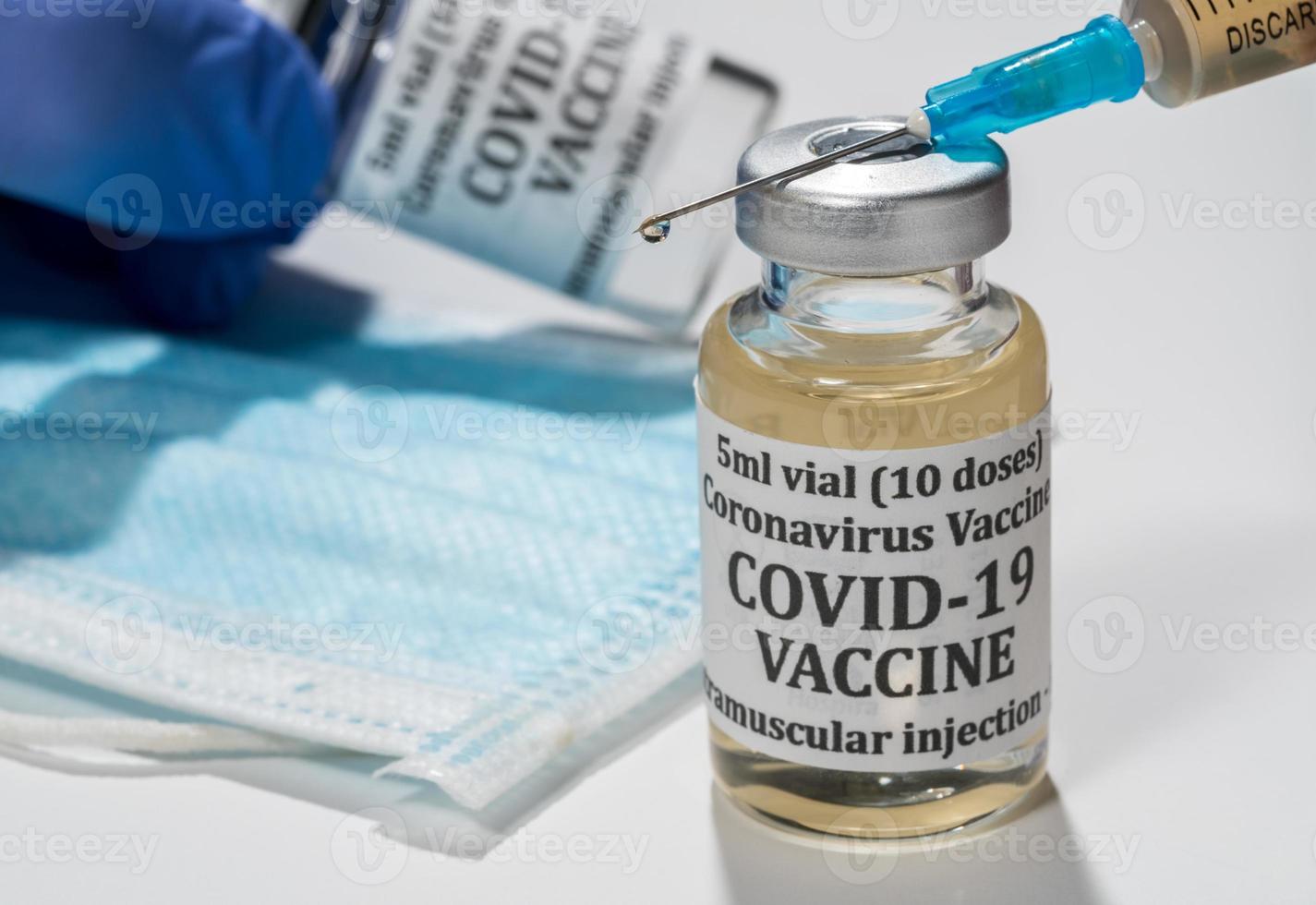 Close up of the end of the hypodermic syringe with droplet of vaccine photo