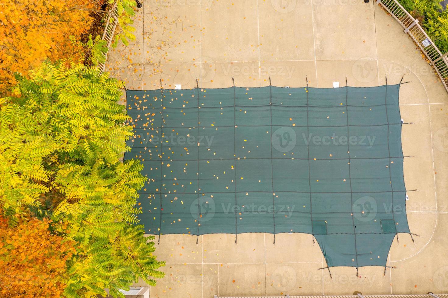 foto aérea de drones de la piscina que cubre la protección de las instalaciones de las hojas de otoño