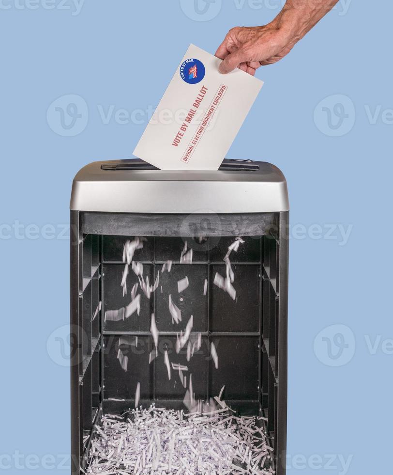 Absentee ballot of vote by mail envelope being shredded in an office shredder photo