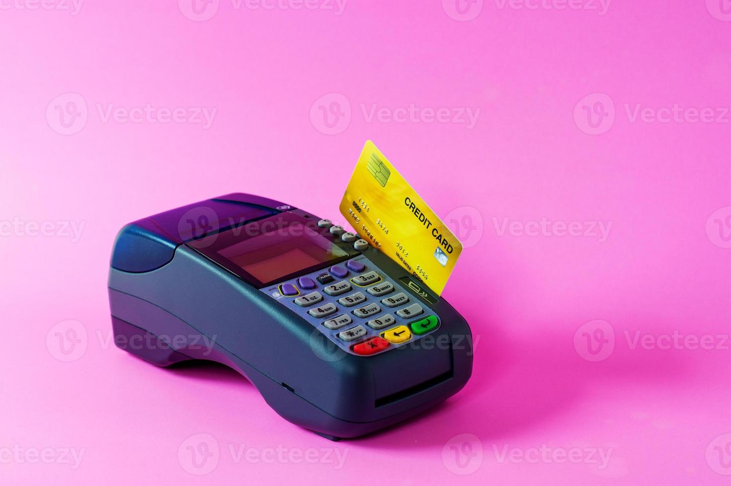 Credit card and credit card scanner on a pink background photo