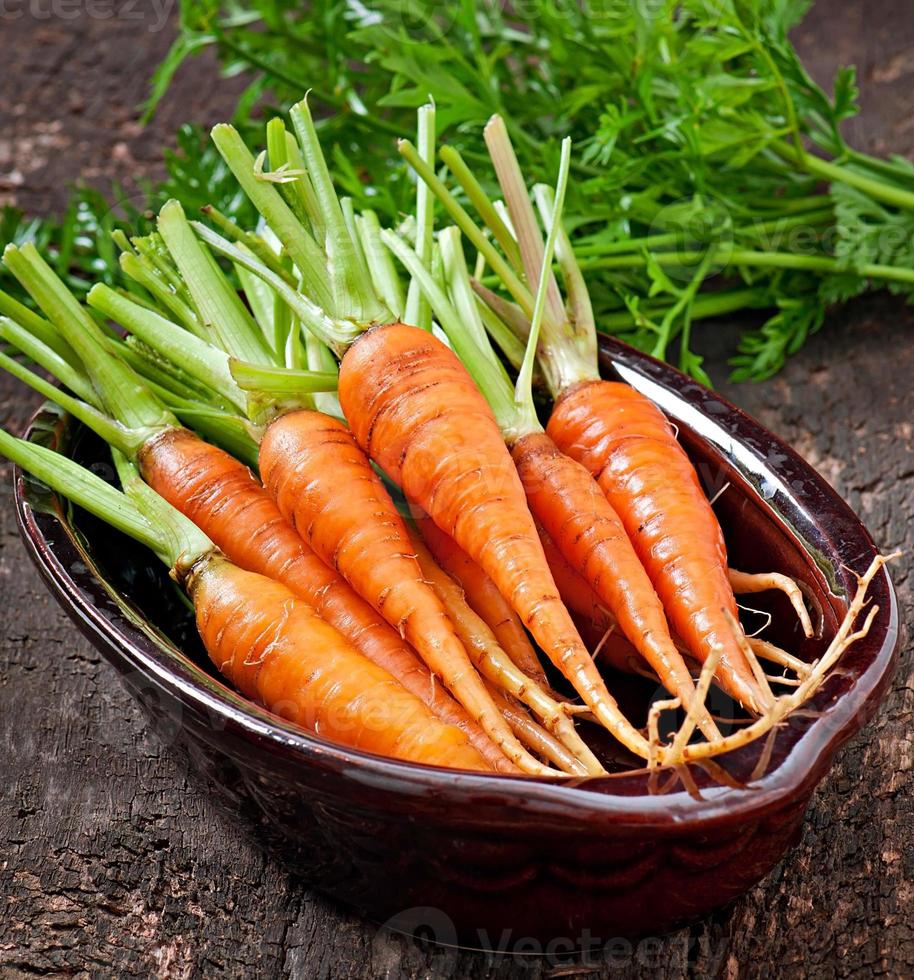 Fresh  carrots on old  wooden background photo