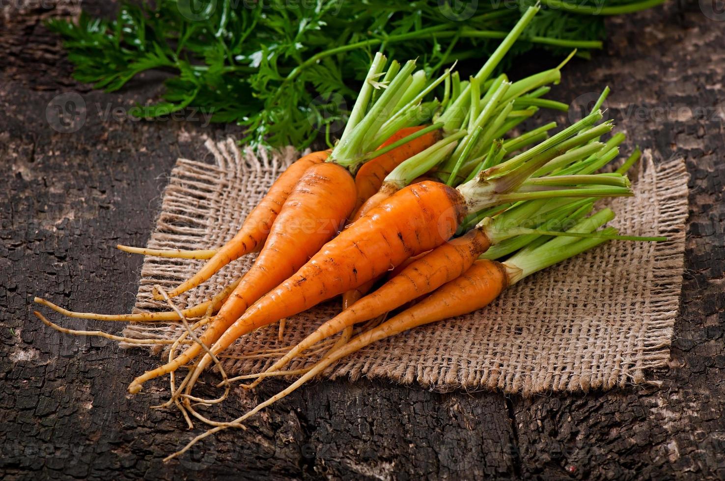 Fresh  carrots on old  wooden background photo