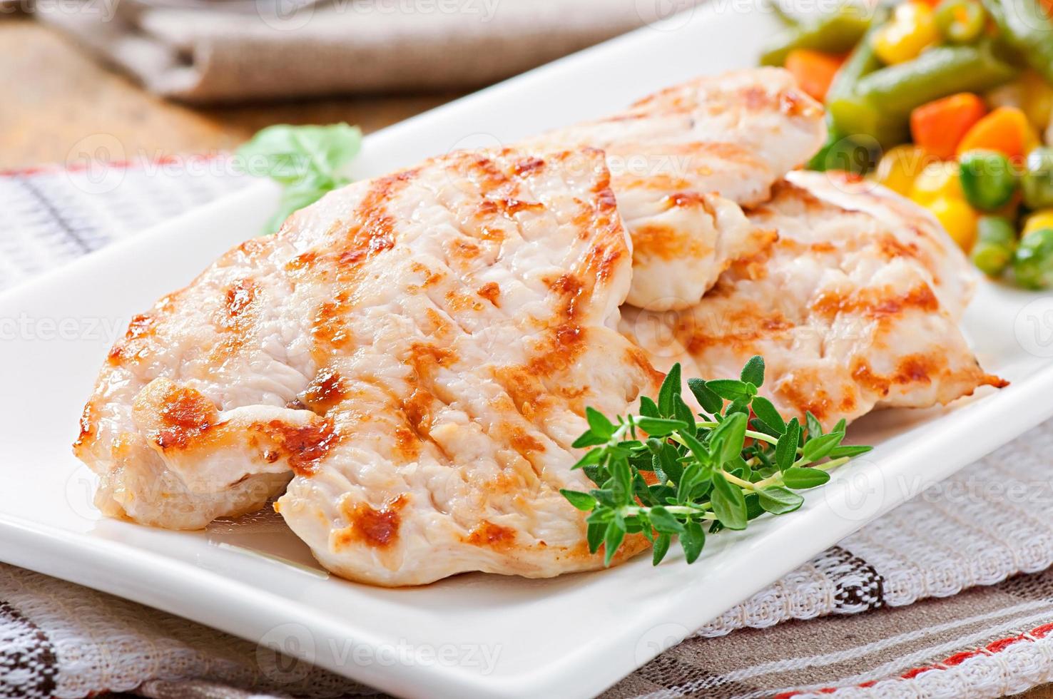 Grilled chicken breasts and vegetables photo