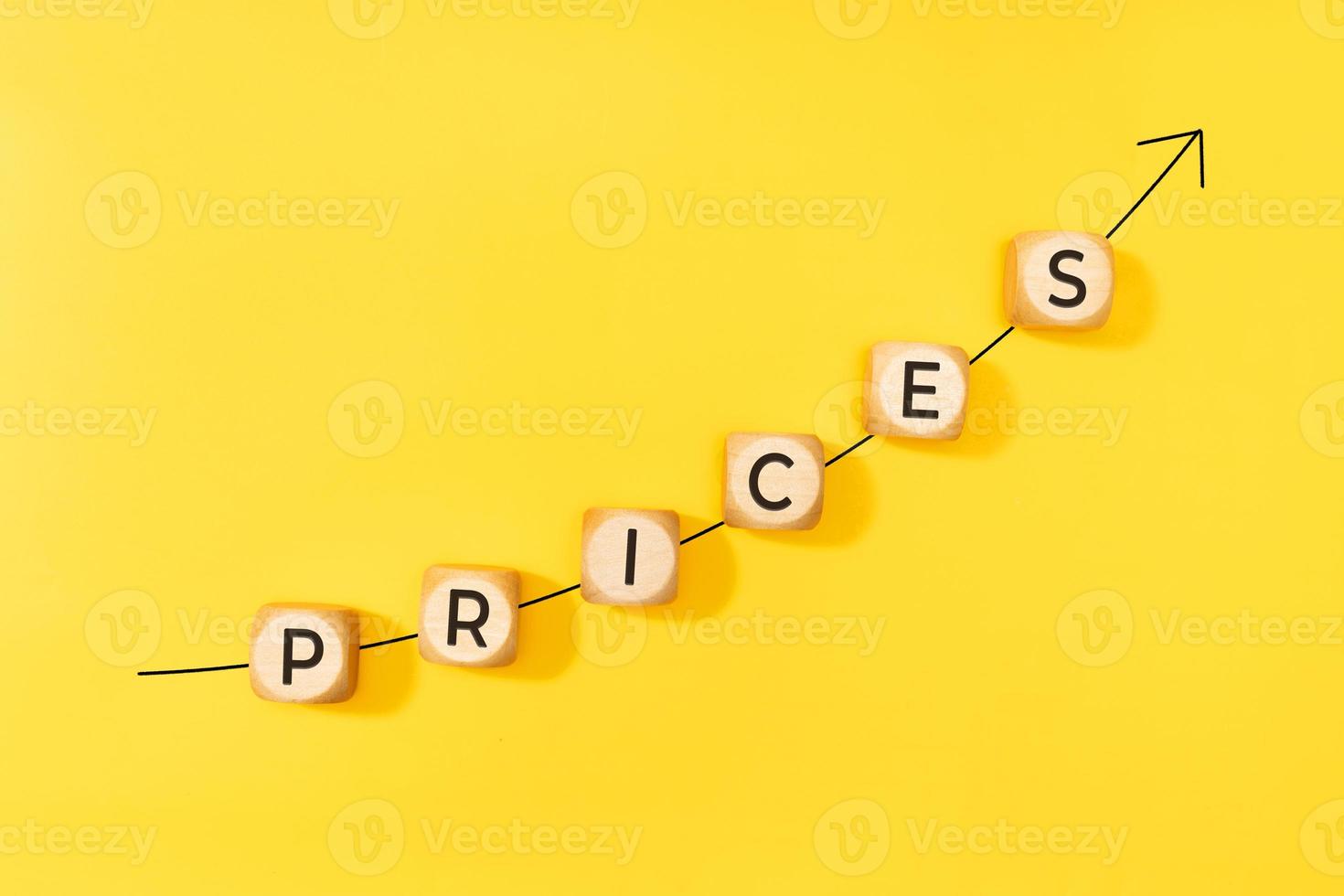 Rising prices concept. Rising arrow and text on wooden blocks on yellow background. Copy space photo