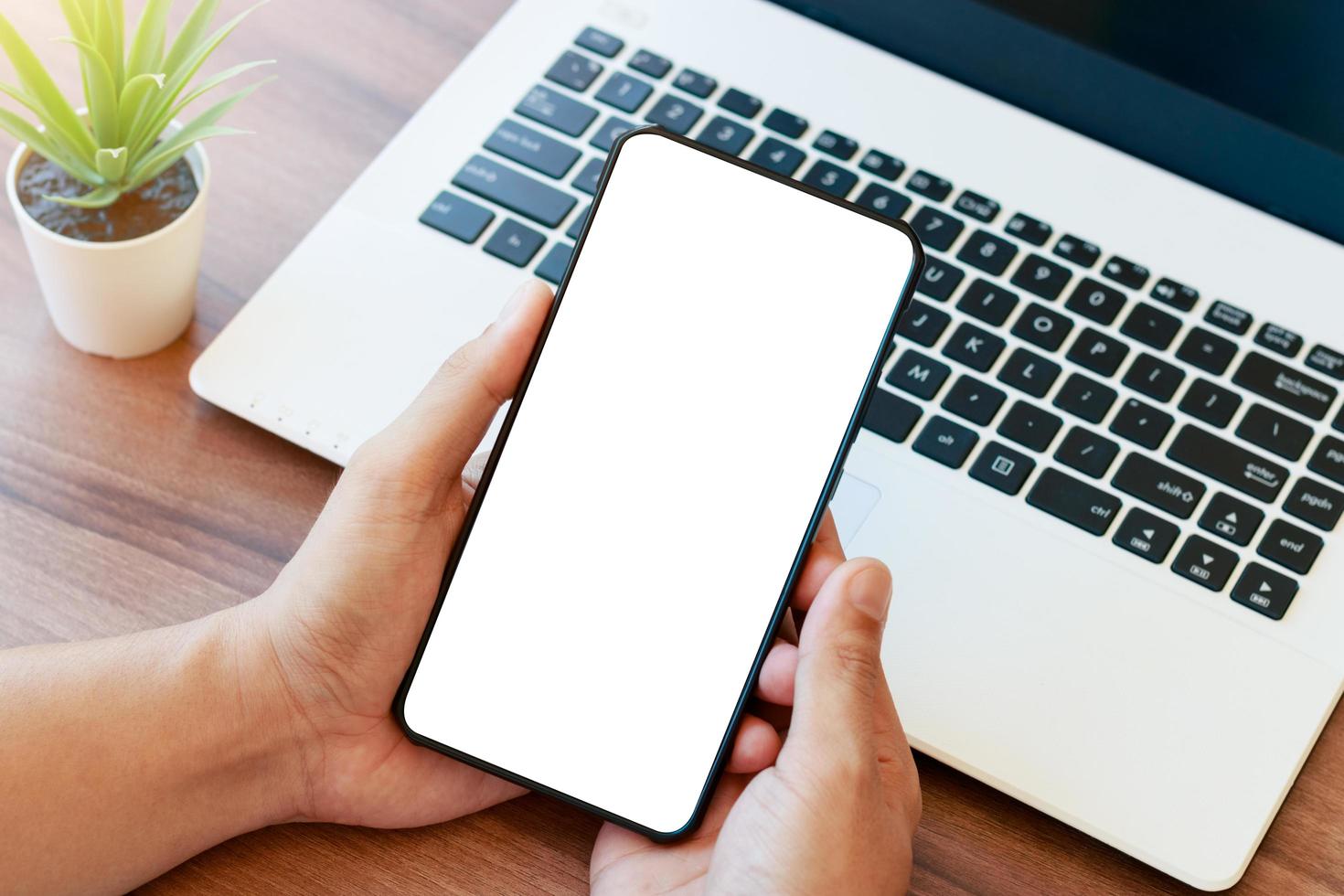 mockup copy space phone, man's hand holding smartphone with blank white copy screen for your advertising and message or information content, mobile on desk at coffee shop. photo